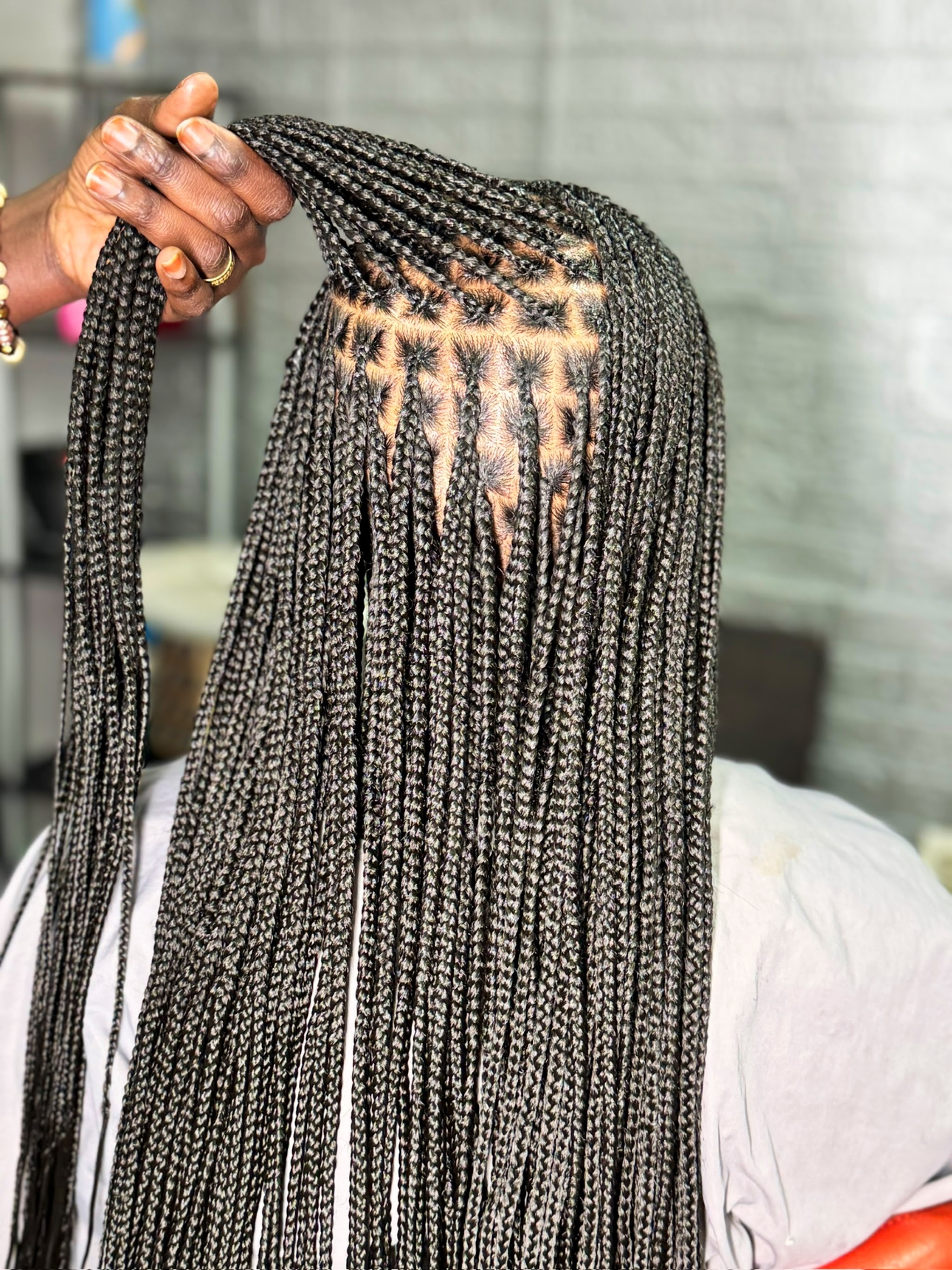 Box braids held up to show the clean parts